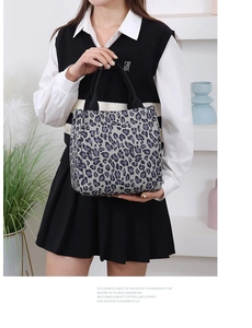 Detail of grey leopard print canvas tote bag with black trim and dual handles
