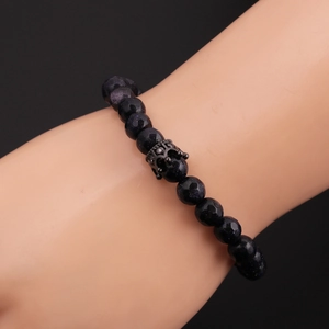 Macro shot of 8mm faceted blue sandstone beads and black crown charm on male bracelet