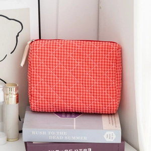 Close-up of red and white checkered quilted cotton makeup bag with metal zipper detail