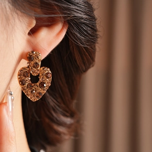 Gros plan de boucles d'oreilles cœur vintage avec strass champagne sur base dorée
