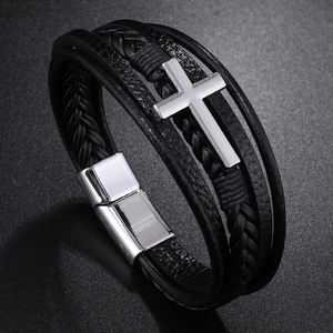 Macro shot of men's multilayer black leather bracelet featuring a silver metal cross charm
