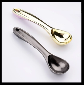 Close-up of professional gold and black self-thawing ice cream scoops on white background