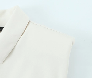 Detail of white crepe fabric texture and clean shoulder stitching on sleeveless dress