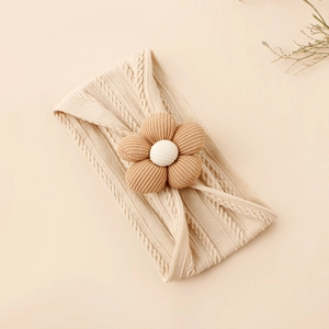 Detail of baby nylon headband with knit cable pattern and brown corduroy flower accessory
