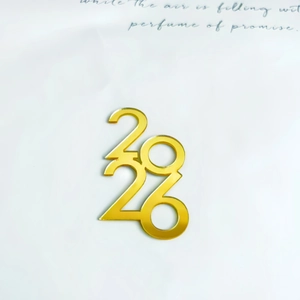 Close-up of golden acrylic 2026 number cake topper with a shiny mirror finish effect