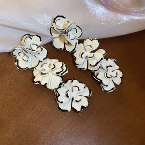 Detail of 3D floral earrings featuring hand-painted black and white contrast petals