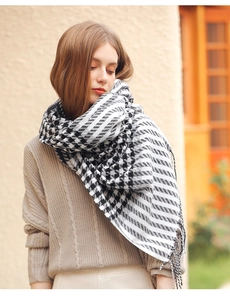 Detailed view of soft black and white houndstooth cashmere-like scarf with fringe edges