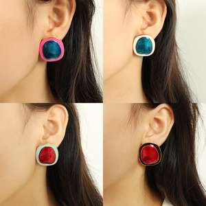 Irregular geometric metal earrings with colorful enamel inlay shown on models