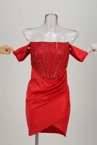 Détail de robe cocktail rouge à épaules dénudées avec corsage pailleté et satin