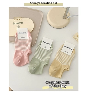 Detailed view of striped combed cotton boat socks in pastel pink, green, and yellow hues