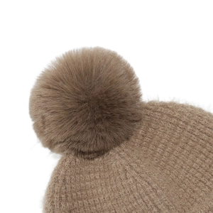 Detailed close-up of the taupe knit beanie featuring a soft faux fur pom-pom detail