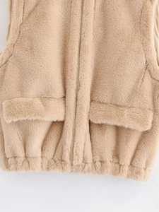 Detailed close-up of soft camel faux fur vest texture with zipper and flap pockets