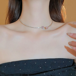 Close-up of a silver-toned open choker featuring two pink square rhinestone accents