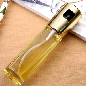 Kitchen glass oil sprayer with gold pump for cooking and grilling on beige fabric