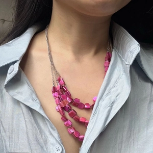 Close-up of pink shell bead multi-layer necklace with bohemian tiered silver chains