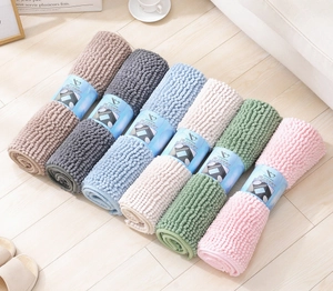 Detailed pile texture of rolled colorful chenille bathroom mats on light wood flooring