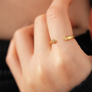 Détail de la bague ouverte plaquée or 18 carats avec deux zircons portés par un mannequin