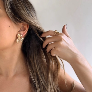 Fashionable gold wing earrings and geometric fluid ring set on female model
