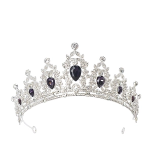 Macro detail of silver tiara featuring clear crystals and deep purple teardrop gemstones