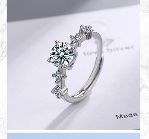 Macro view of silver cubic zirconia ring with large round center stone on marble surface
