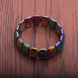 Close-up of rainbow metallic magnetic hematite bracelet with rectangular beads on wood