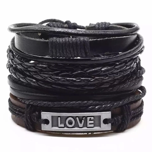 Détail de bracelets en cuir multicouches avec cordes tressées et plaque en métal LOVE