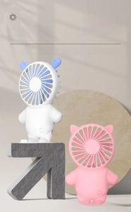 Detail showing cute astronaut mini fans in white and pink with matte plastic finish