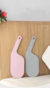 Close-up of pink and grey bed sheet sorter tools leaning against a wooden headboard