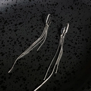 Close-up detail of elegant silver tassel earrings with sparkling cubic zirconia stones
