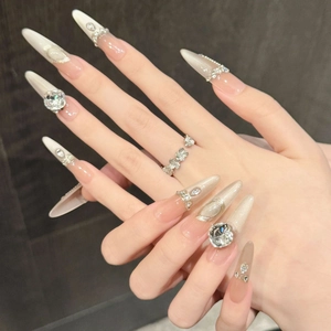 Detailed view of luxury champagne cat-eye stiletto press-on nails with silver rhinestones