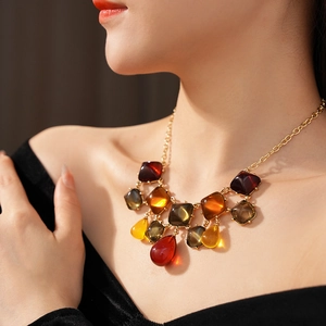 Modella che indossa orecchini vintage in resina ambrata con pendenti quadrati e a goccia