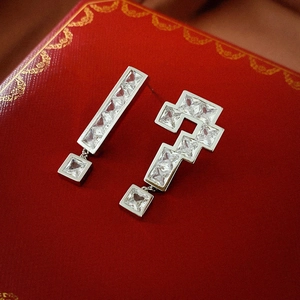 Macro view of asymmetric exclamation and question mark earrings with sparkling zircon stones