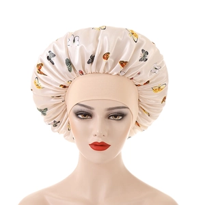 Detail of butterfly print satin sleep bonnet with wide elastic band on head model