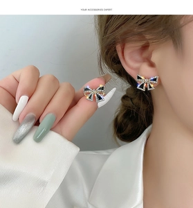 Detail of s925 black bow earrings with gold plating and sparkling zircon accents