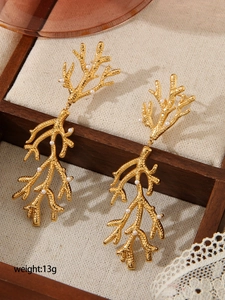 Détail de boucles d'oreilles branche de corail plaquées or 18 carats et perles
