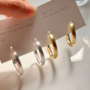 Minimalist brushed metal hoop earrings in gold and silver finish shown on card