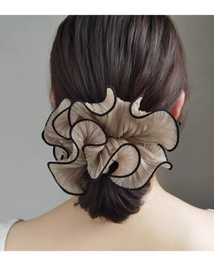 Detail of a champagne mesh scrunchie with black contrast edges on a ponytail