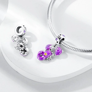 Macro detail of Scorpio zodiac charm with purple enamel finish and silver engraving
