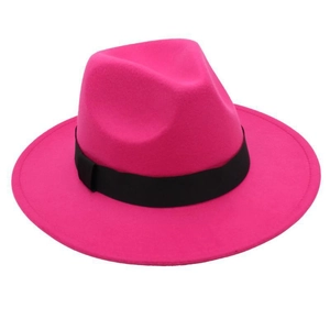 Detail of fuchsia wide brim fedora hat with classic black ribbon accent and felt texture