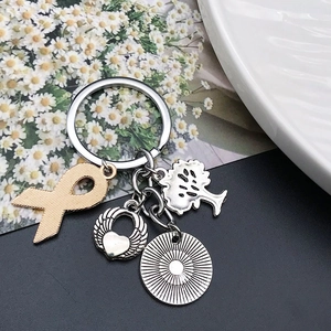 Detail of silver Tree of Life and winged heart pendants on a metal keychain