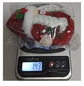 Détail d'un gnome de Noël lesté avec des paillettes rouges et des tresses blanches