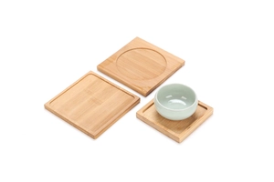 Detailed view of square bamboo coasters and a small light cyan ceramic teacup set