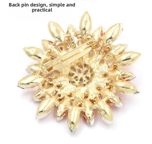 Detail view of the gold flower brooch back showing the safety pin fastener and petal layers