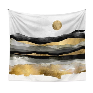 Detail of modern abstract mountain tapestry with gold foil sun on a white wall
