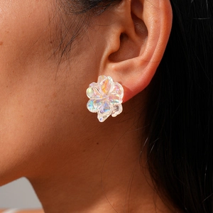 Close-up of iridescent floral resin earring worn by a model with elegant pearly details