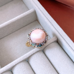 Close-up of 18k gold plated ring with pink pearl and colorful stone inlay details
