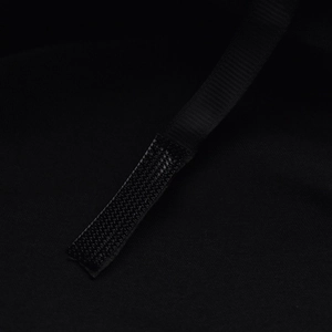 Close-up of black wool beret showing adjustable hook-and-loop strap detail for custom fit