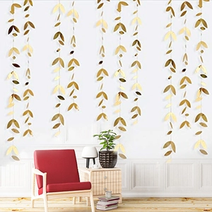 Detail of hanging gold leaf garlands for wedding decoration in a cozy living room setup
