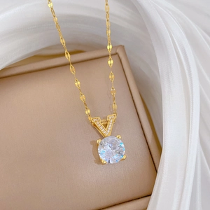 Gros plan d'un collier en V doré avec zircon rond brillant dans un coffret cadeau