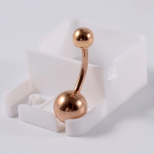 Détail de piercing de nombril en acier inoxydable or rose avec design à double bille